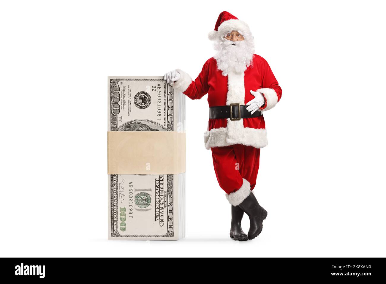 Babbo natale appoggiato su una pila di banconote in dollari isolate su sfondo bianco Foto Stock