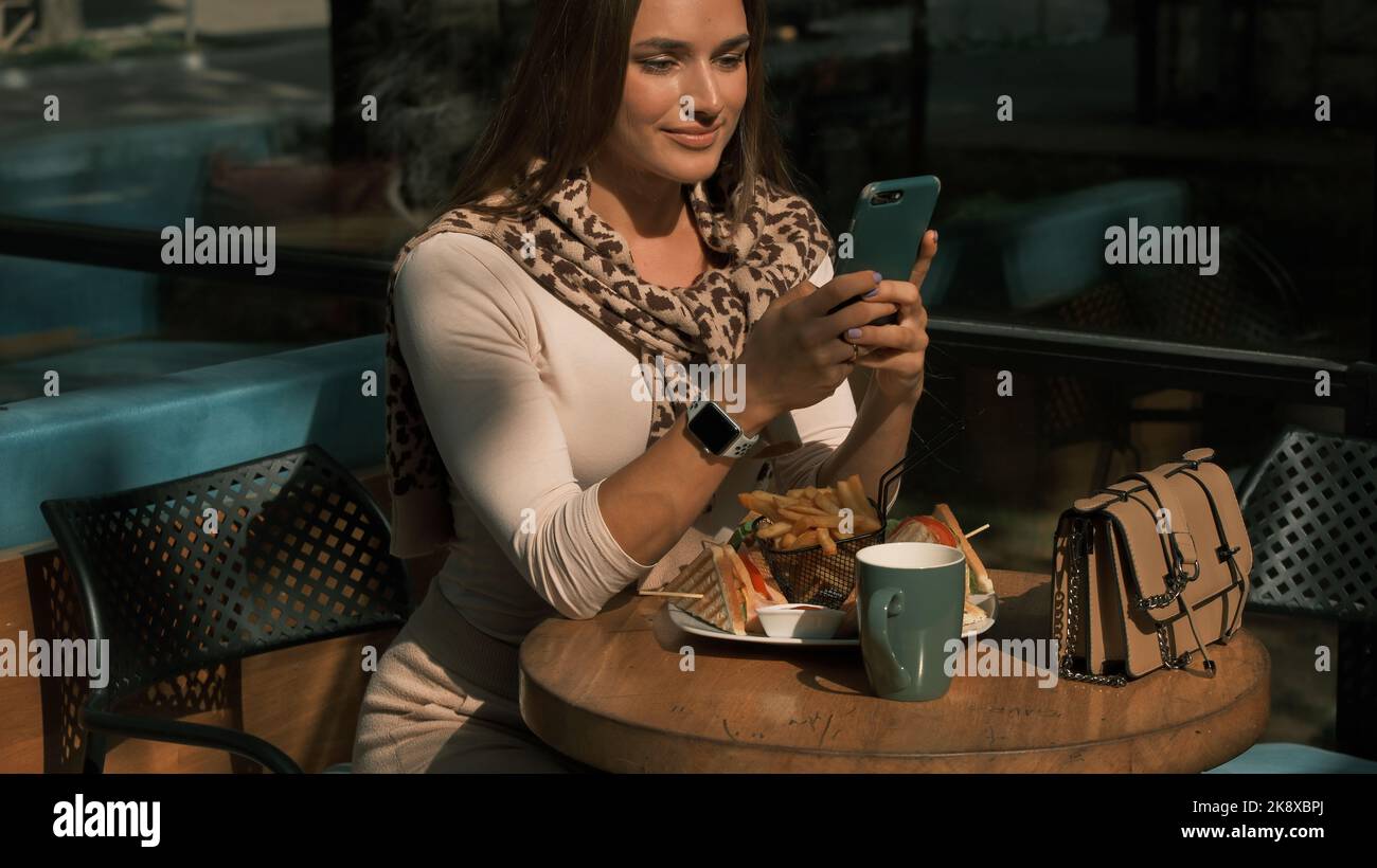 La ragazza tiene in mano un telefono cellulare e compone un numero Foto Stock