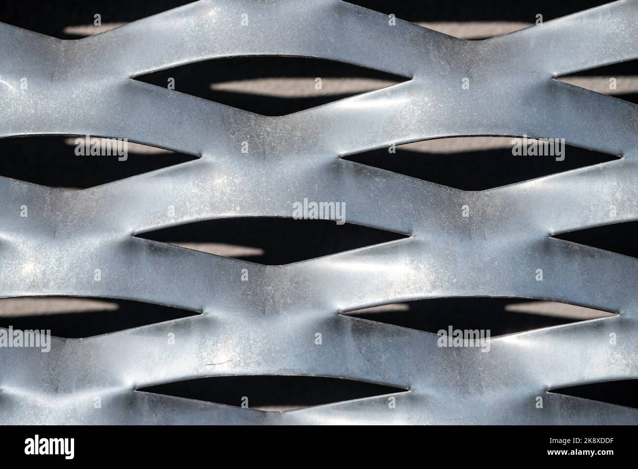 Struttura della piastra di stampaggio in lamiera perforata - vista frontale. Riflessione della luce e ombra. Foto Stock