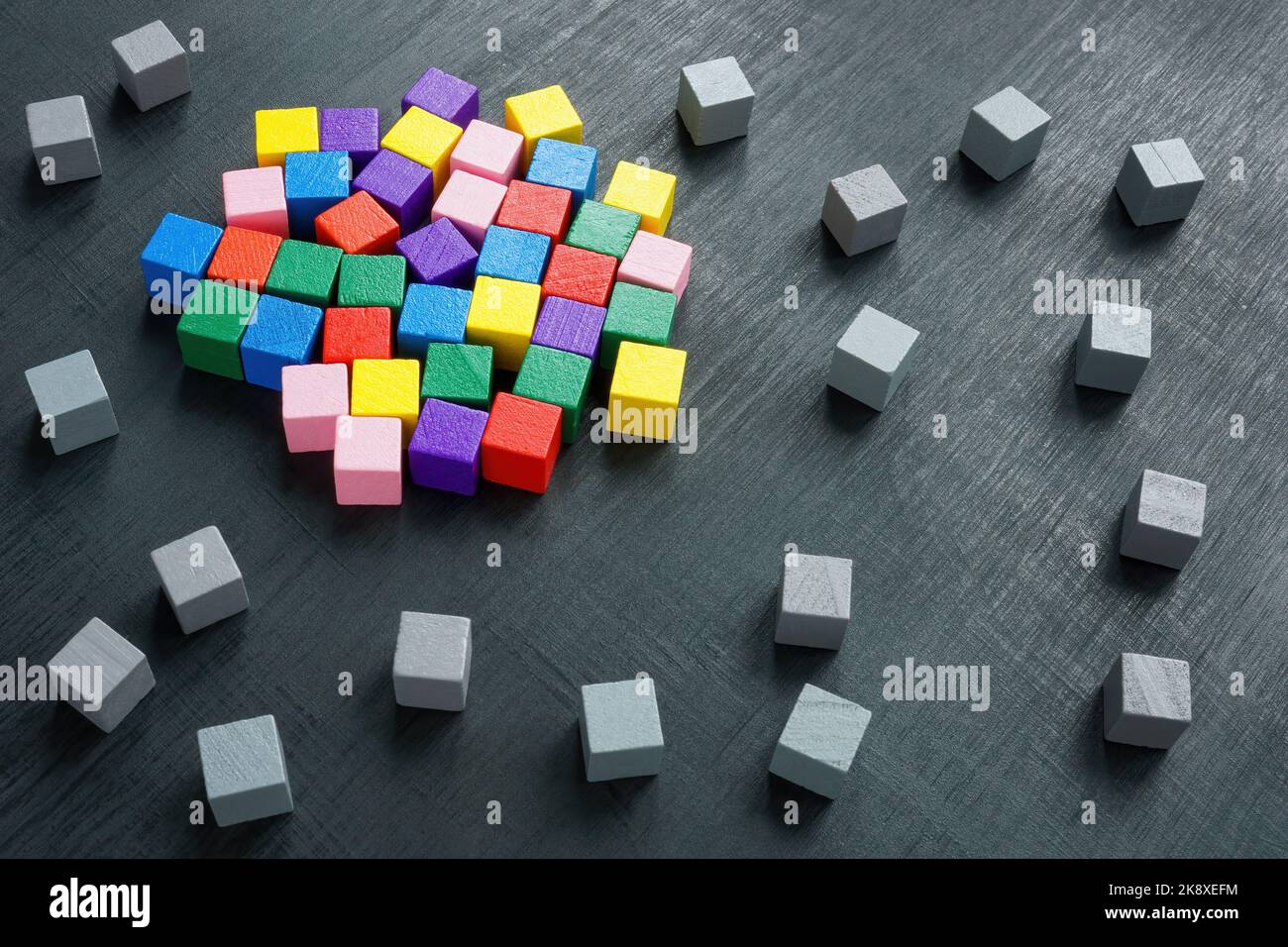 Concetto di integrazione, diversità e inclusione. Cubi multicolore circondati da quelli grigi. Foto Stock