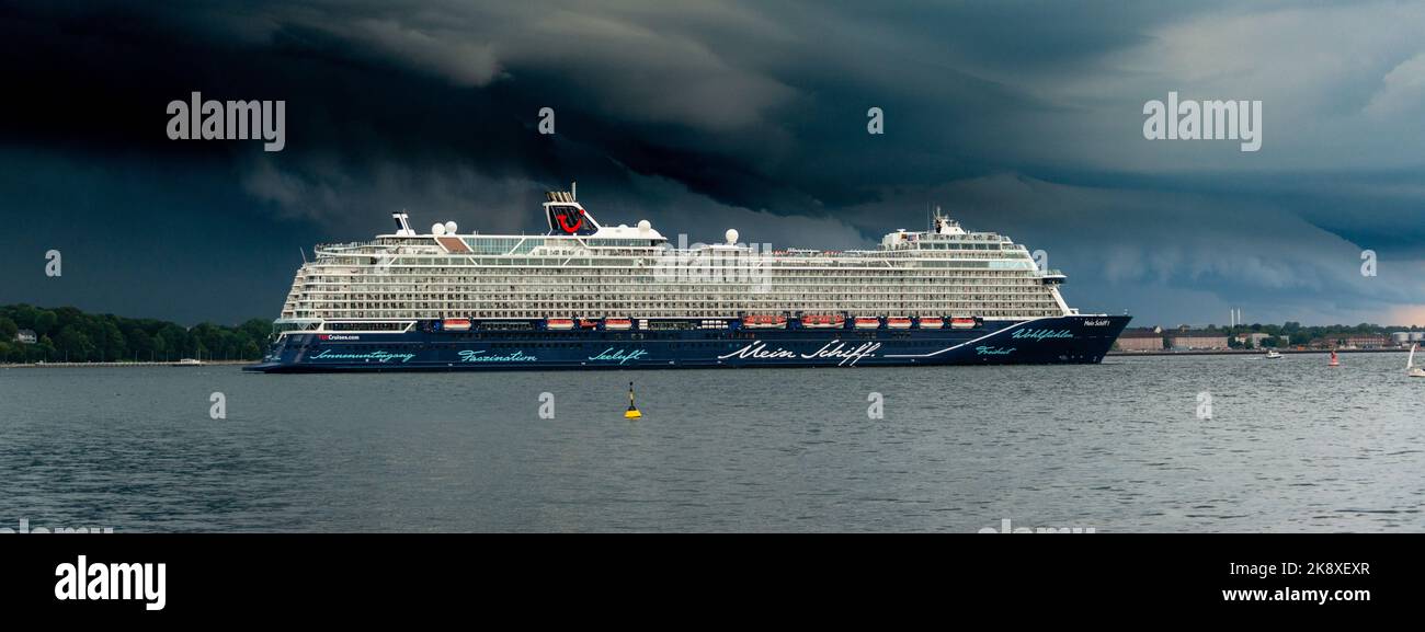 Kiel, Deutschland, Juli 2019 Dunkle Wolken über der Kieler Innenförde. Ein Gewitter mit Wolkenbruch kündigt sich an während das Kreuzfahrtschiff Mein Foto Stock