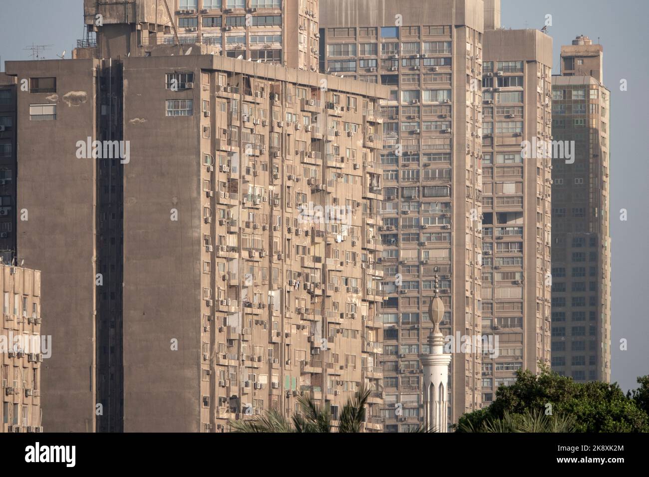 Una fila di alti blocchi di appartamenti, tutti con balconi, aria condizionata e piatti TV, sulla riva del Nilo Foto Stock
