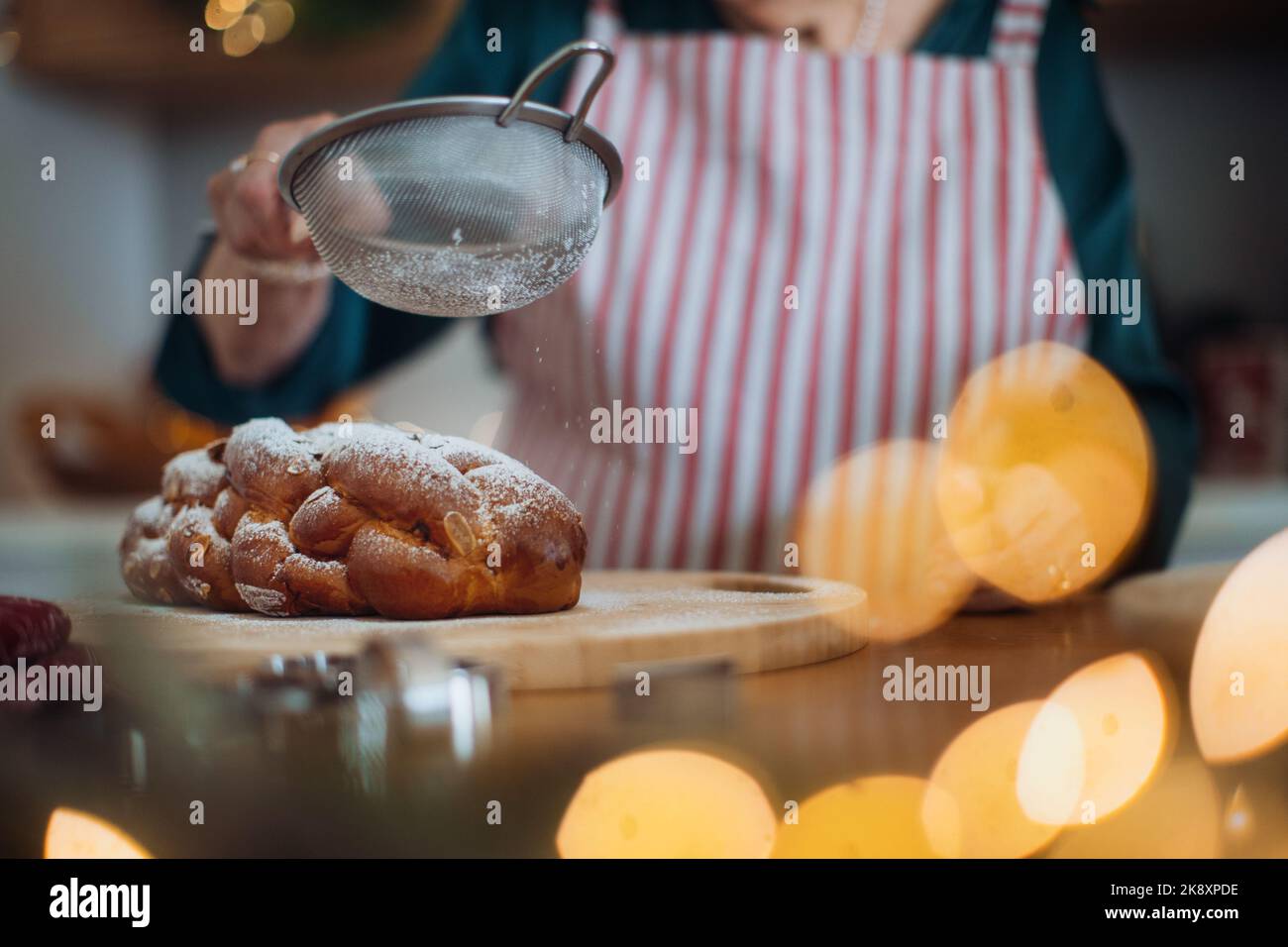 Primo piano della donna anziana che cuoce il pane di Natale. Foto Stock