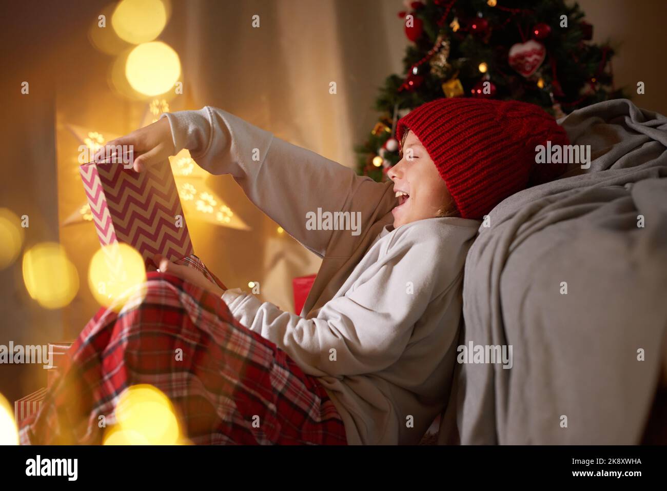 Kid reazione al regalo di Natale di apertura carta di Capodanno adorabile personaggio regali che danno la tradizione Foto Stock