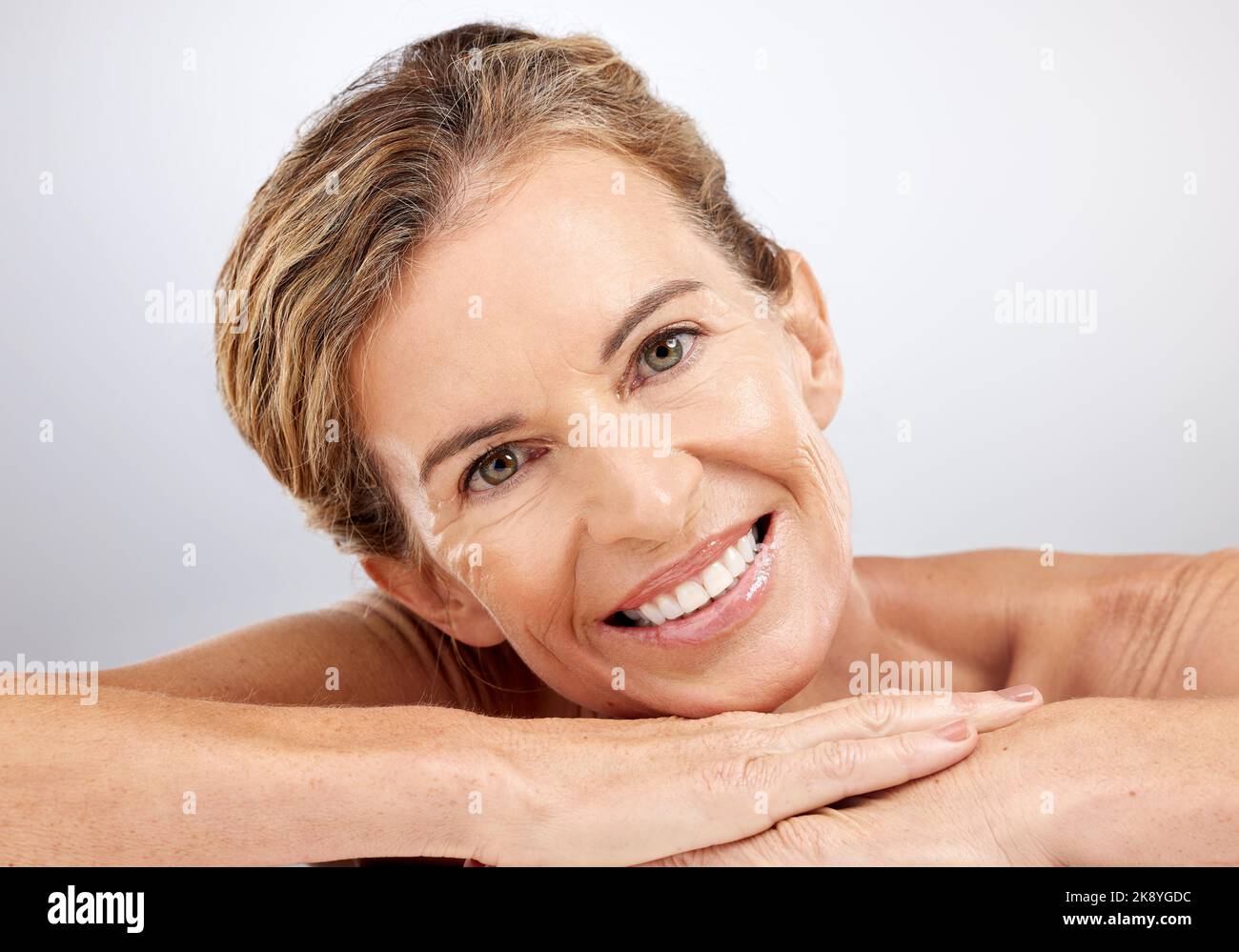 Donna anziana, relax e bellezza per la cura della pelle con sorriso per cosmetici, viso o trattamento su uno sfondo grigio studio. Ritratto di anziani felici Foto Stock