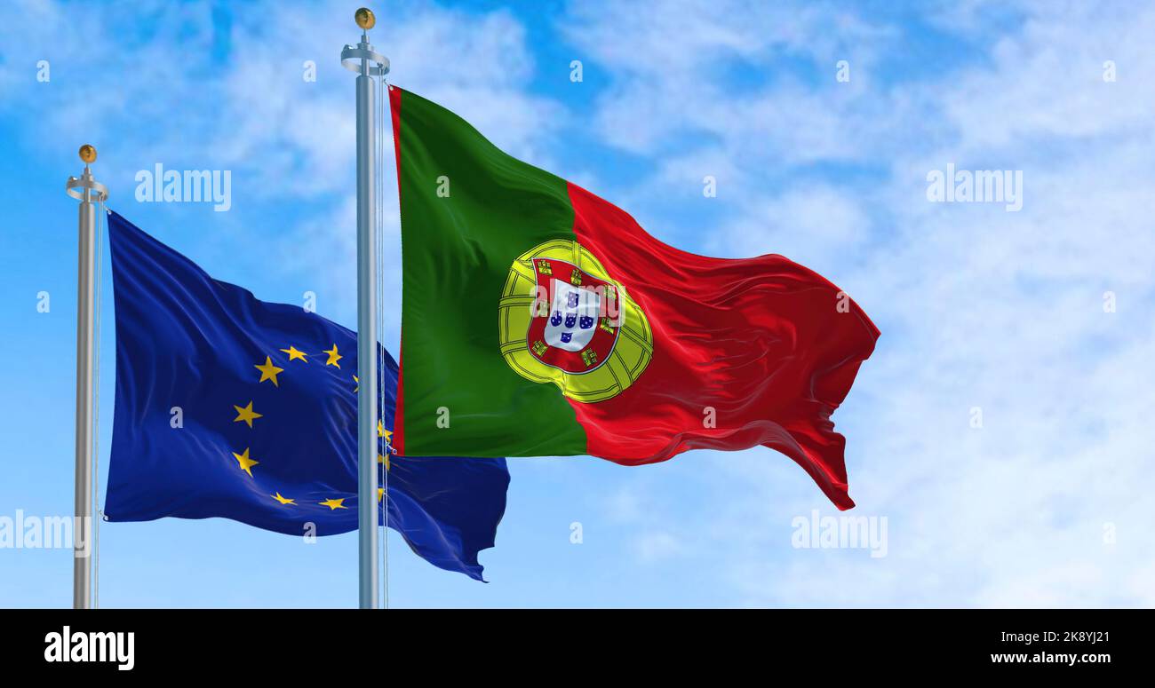 La bandiera nazionale del Portogallo sventola al vento con la bandiera dell'Unione europea in una giornata limpida. Democrazia e politica. Paese europeo. Focus selettivo Foto Stock