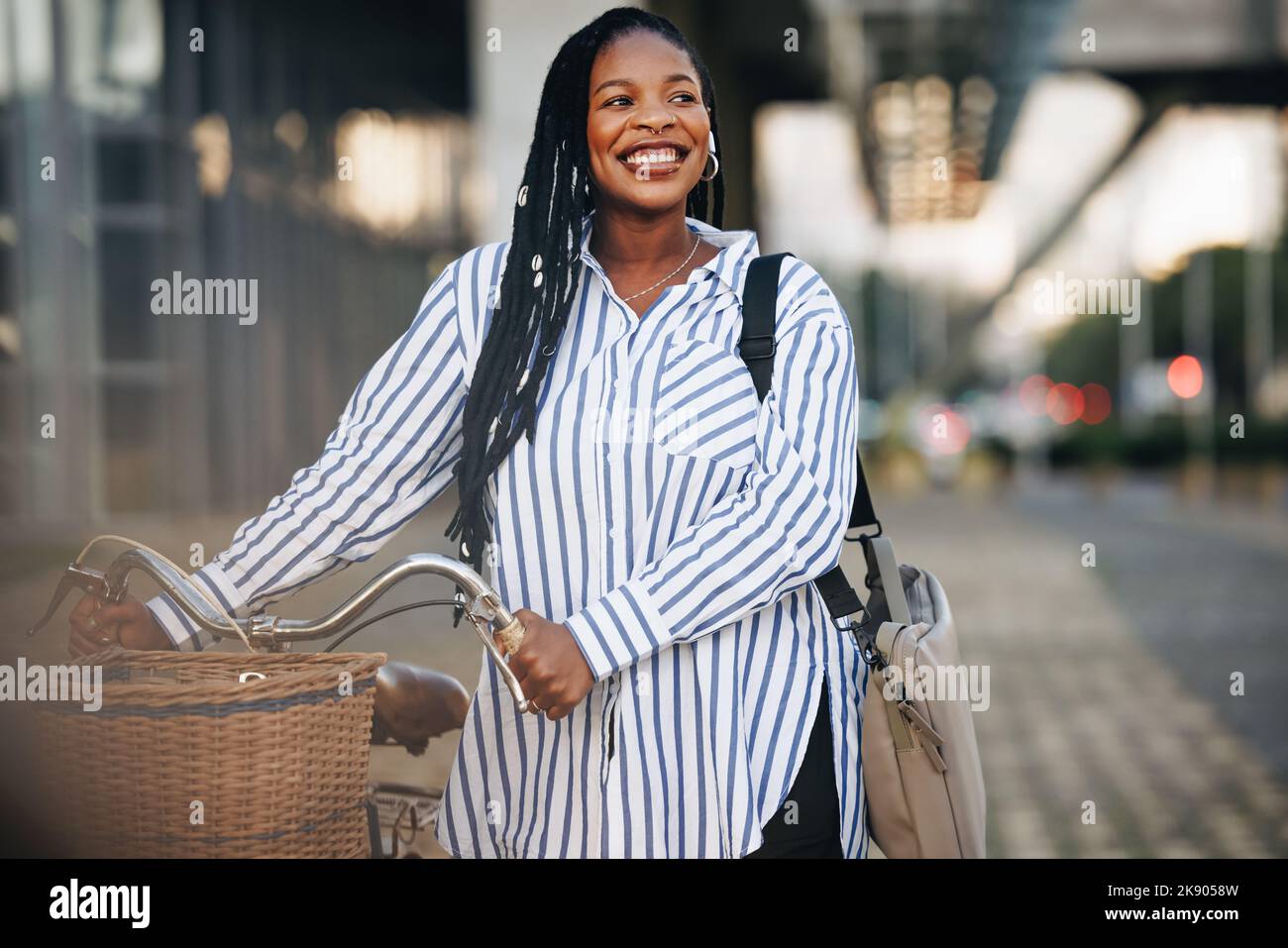 Giovane donna d'affari eccitata sorridente allegro mentre spinge la sua bicicletta sulla sua strada per lavorare in città. Felice giovane donna d'affari che si collega a lei o Foto Stock