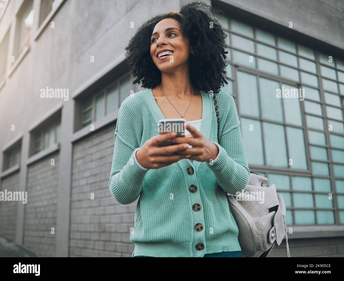Social media, città e donna con un telefono per la posizione gps, Internet e app mobile in una strada. Ragazza felice, giovane e africana con uno smartphone per Foto Stock