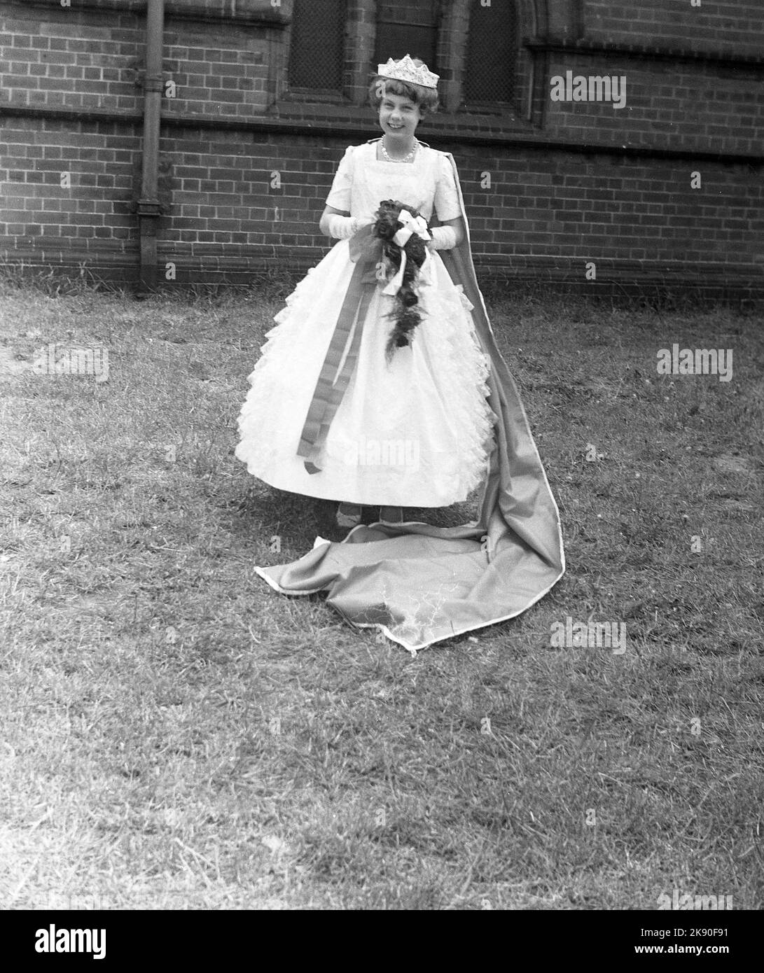 1962, storica, il giorno di maggio, eccitata ragazza adolescente, quest'anno la regina di maggio, nella sua abito e indossando la sua corona, Leeds, Inghilterra, Regno Unito Foto Stock