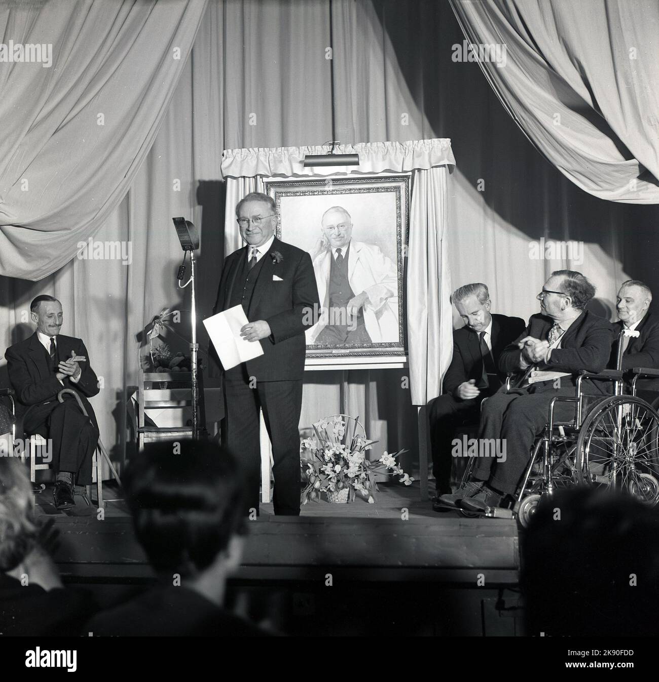 1965, storico, Stoke Mandeville Hospital, Dr. Ludwig Guttmann in un palco che ha tenuto un discorso ad una festa che celebra il 21st° anniversario della fondazione del National Spinal Injury Centre, Aylesbury, Buckinghamshire, Inghilterra, Regno Unito. L'evento anniversario ha incluso la presentazione di un ritratto del neurologo tedesco-britannico, che oltre a costituire il centro di trattamento pionieristico per i disabili, è stato anche il fondatore dello Stoke Mandeville Games, un evento sportivo per i disabili, precursore delle moderne Paralimpiadi. Foto Stock