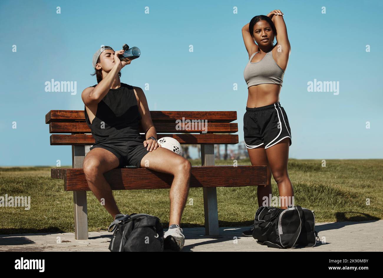 Uomo, donna e pausa fitness per stretching, acqua potabile o recupero muscolare dopo l'allenamento, l'esercizio fisico e l'allenamento. Giocatori di calcio, amici sportivi o. Foto Stock