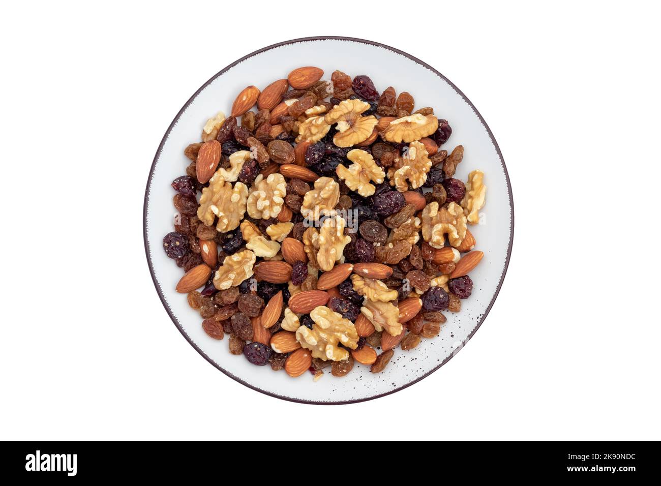 Snack salutare: Frutta secca e noci miste in piastra di ceramica isolata su sfondo bianco. Mandorla, noce, mirtillo, uva passa. Vista dall'alto. Vegetariano fo Foto Stock