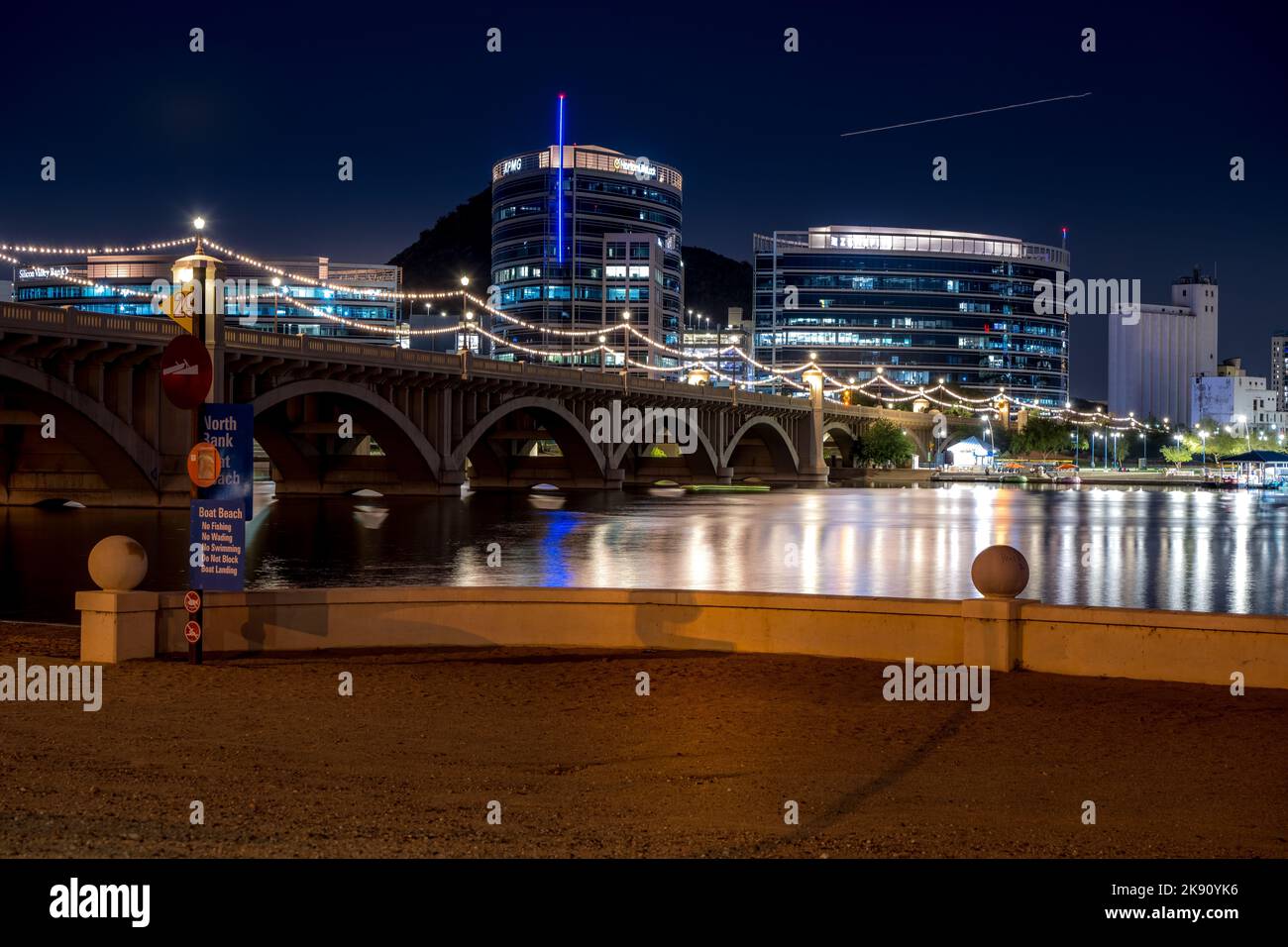Un'inquadratura dal basso del lago Tempe Town e degli edifici e ponti vicini di notte, Arizona Foto Stock