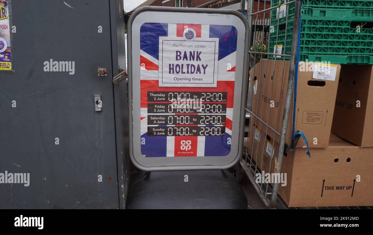 Queens Platinum Jubilee, 2022. Firma gli orari di apertura presso un negozio Co Op durante questa speciale festività bancaria, con Union jack. Tuttavia, il negozio non è mai stato chiuso. Scena di strada mondana. Foto Stock