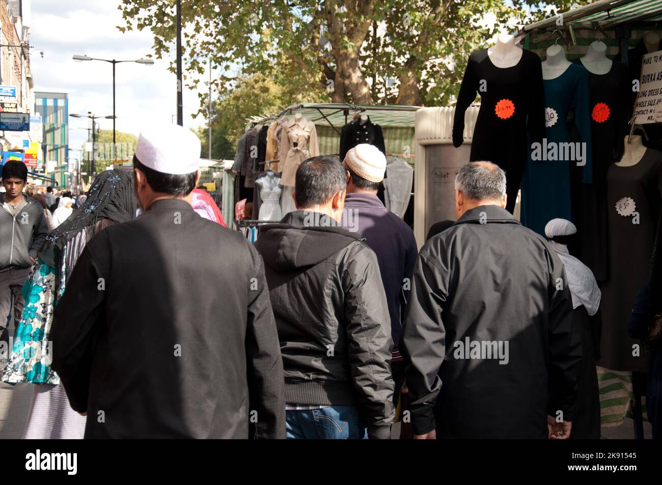 Uomini con calotte arabe/islamiche che camminano lungo Whitechapel, Tower Hamlets, East End, Londra Foto Stock