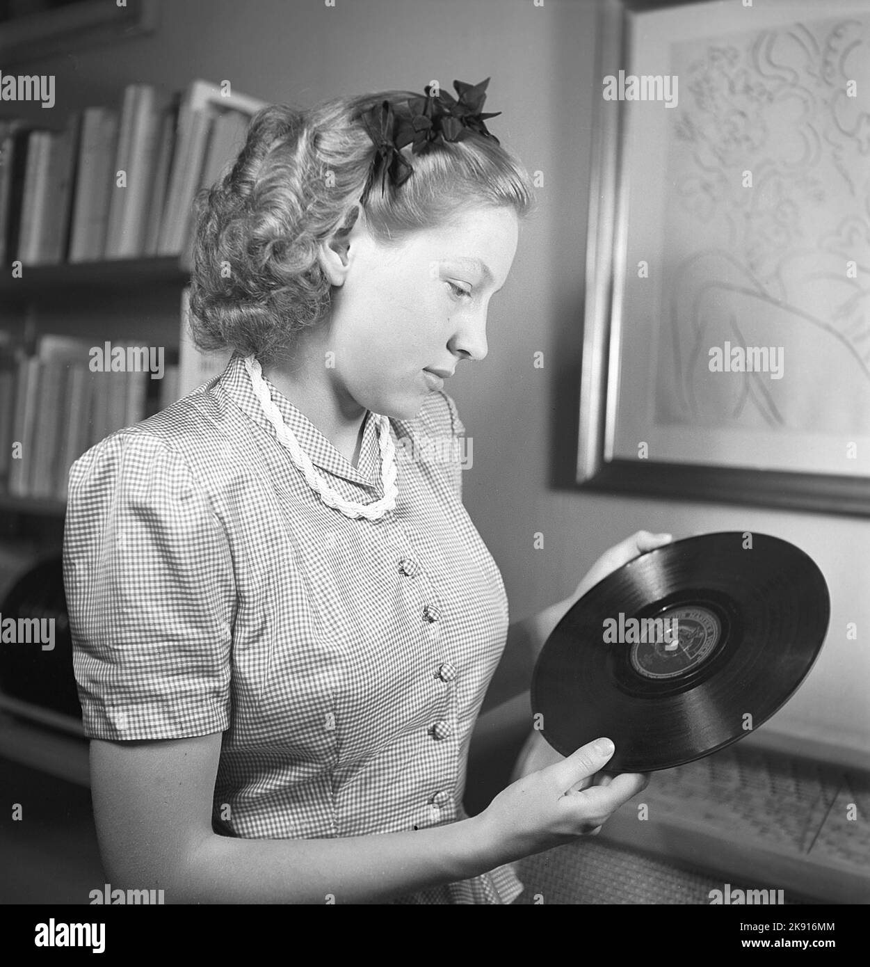 Donna degli anni '1940s. Una giovane donna detiene un record di grammophone del tipo a 78 giri/min. Realizzato in materiale fragile che si rompe facilmente e si graffia. Svezia 1945 Kristoffersson Ref O141-6 Foto Stock