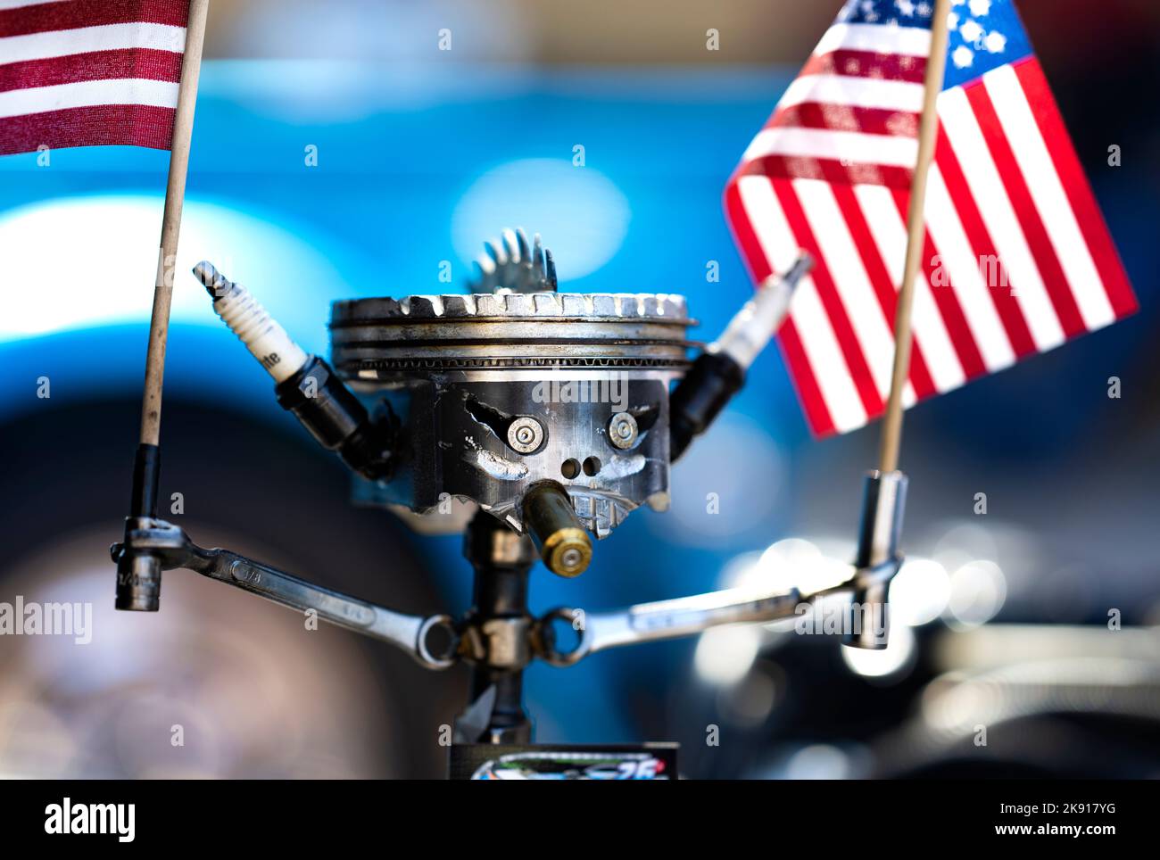Un primo piano di un robot realizzato con parti di auto che detengono una bandiera americana in Winslow AZ Foto Stock
