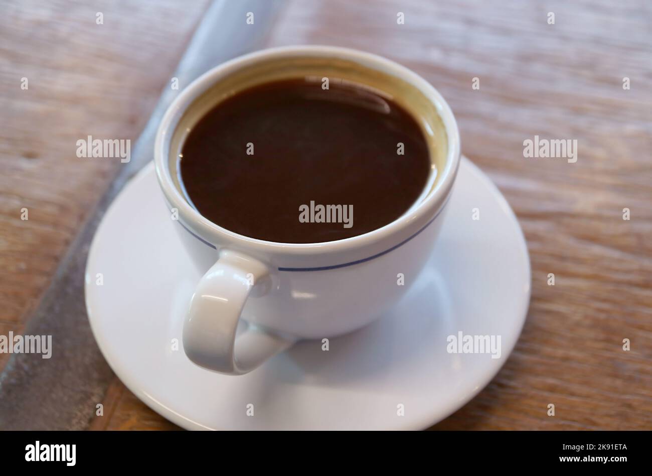 Una tazza di caffè caldo aromatico isolato su un tavolo di legno Foto Stock