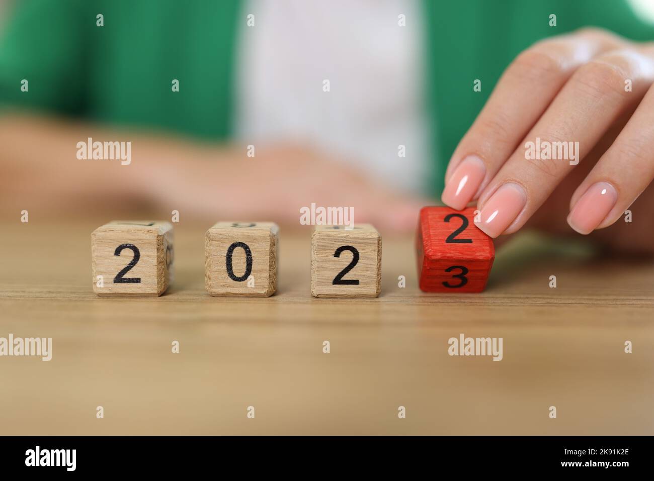 Il ribaltamento a mano femmina del blocco di cubo di legno cambia da 2022 a 2023 Foto Stock