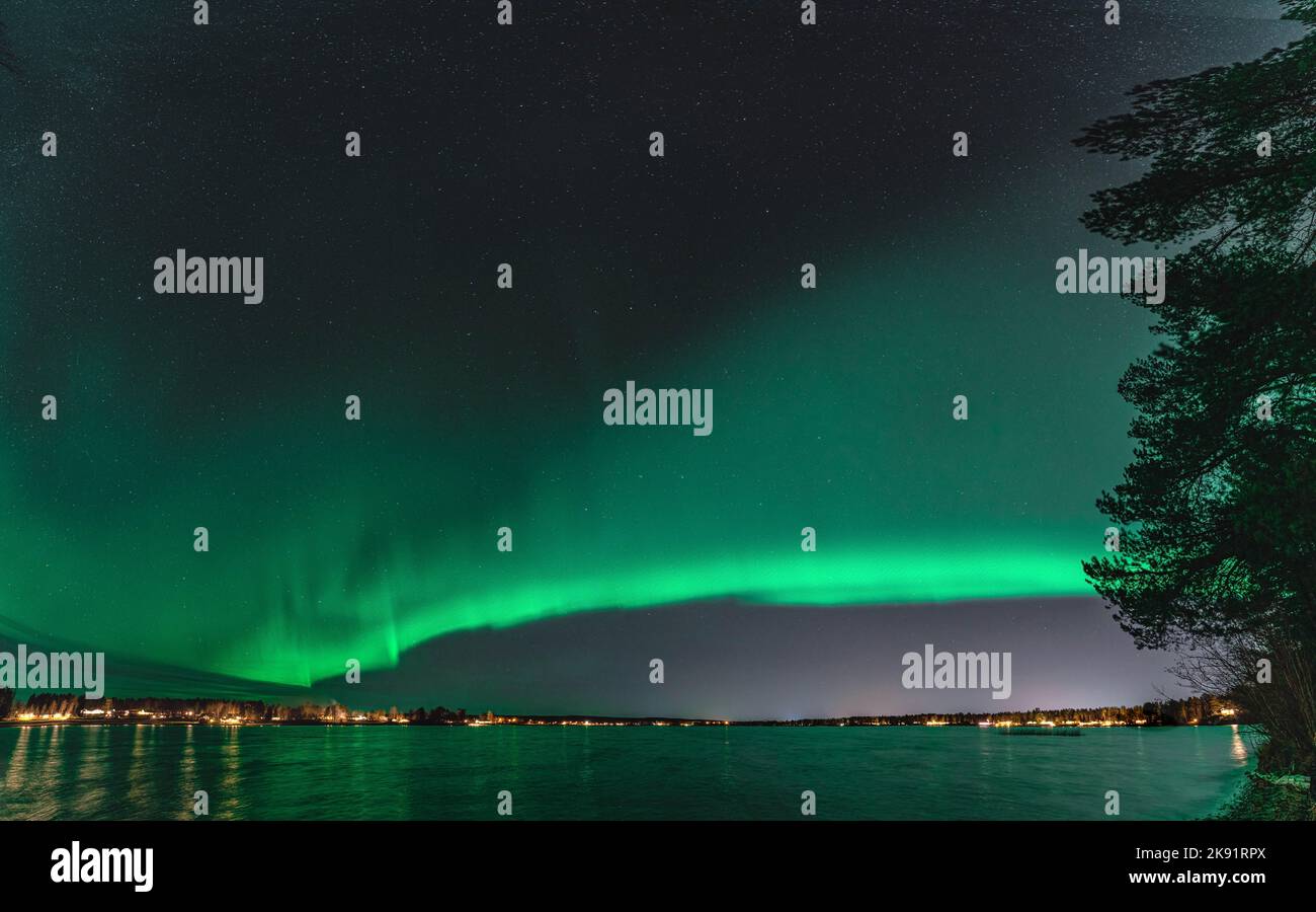 Panoramico ampio panorama dell'aurora boreale, l'aurora boreale sulla tranquilla notte del lago Stocksjo nella Svezia settentrionale, città di Umea. Riflesso dell'aurora nella superficie dell'acqua. Foto Stock