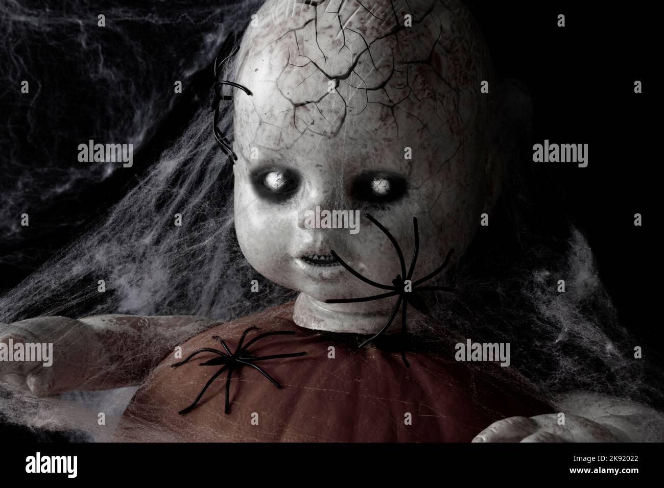 Ritratto di bambola zombie. Sfolgorante volto di bambola con occhi bianchi e pelle zombie su sfondo nero. Concetto di Halloween. Foto Stock