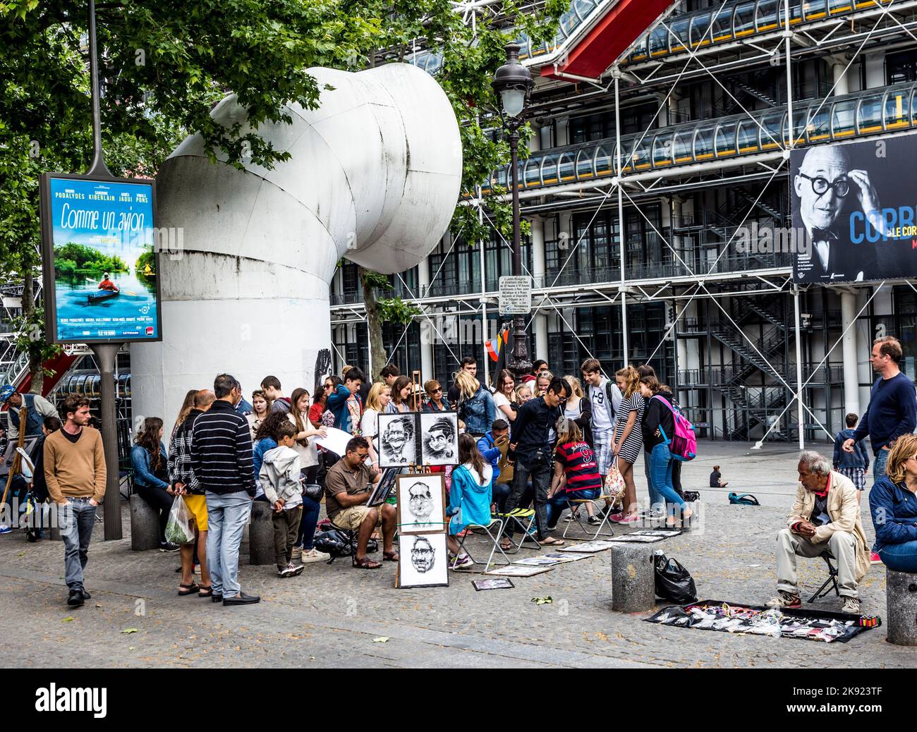 PARIGI, FRANCIA - 9 GIUGNO 2015: I giovani del centro pompidou si divertono a essere disegnati da artisti per piccoli soldi in pose divertenti. Foto Stock