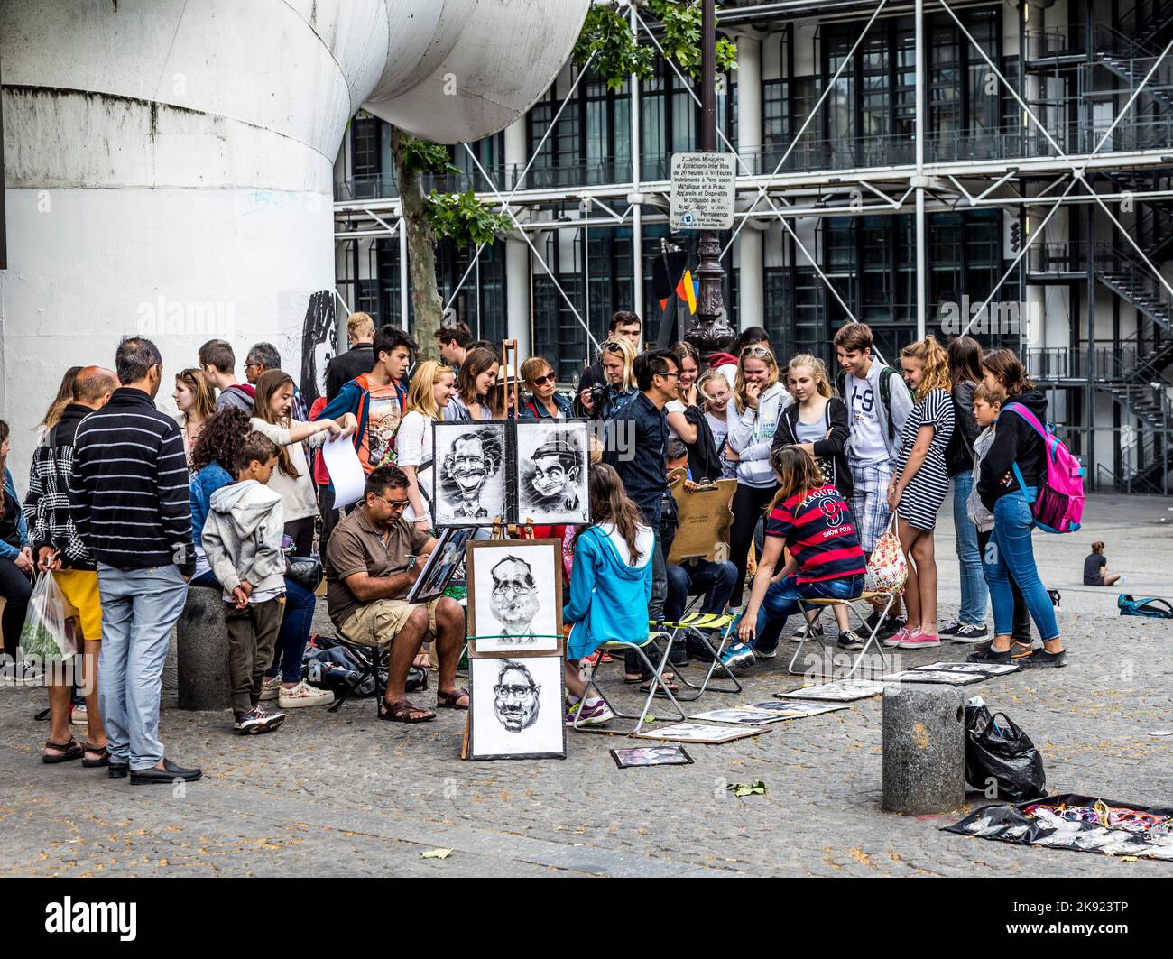 PARIGI, FRANCIA - 9 GIUGNO 2015: I giovani del centro pompidou si divertono a essere disegnati da artisti per piccoli soldi in pose divertenti. Foto Stock