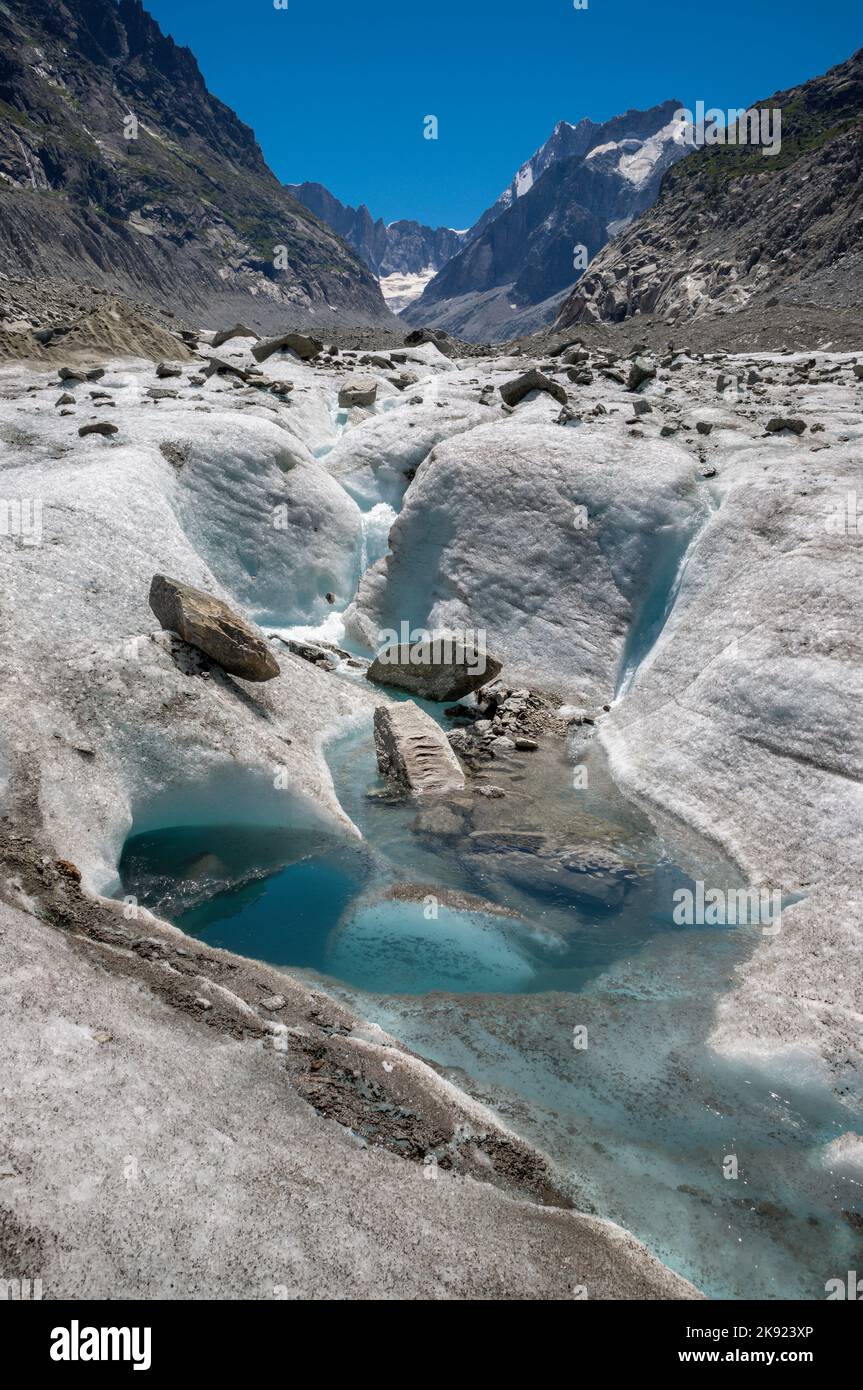 Il torrente glaciale sul ghiacciaio Mer de Glace con il Garand Jorasses sullo sfondo. Foto Stock