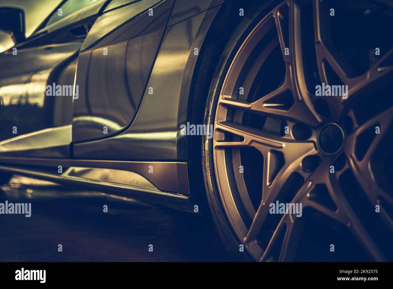 Dettagli sul design degli esterni delle auto sportive di lusso. Cerchio dorato Closeup. Trasporti e tema automobilistico. Vista a livello della strada. Foto Stock