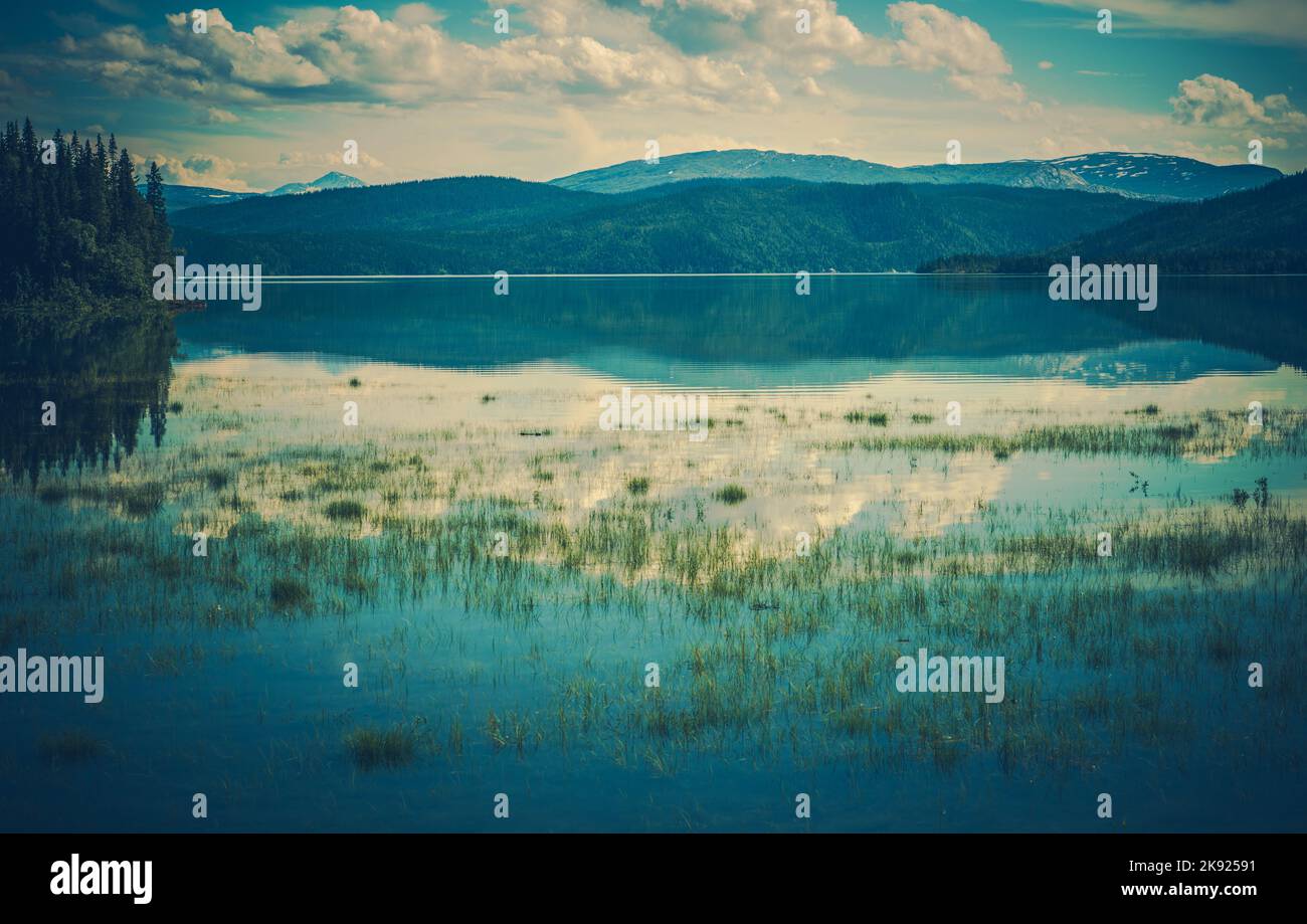 Grande lago blu con montagne sullo sfondo. Paesaggio panoramico. Vista mozzafiato e tranquilla. Tema Fotografia natura. Foto Stock