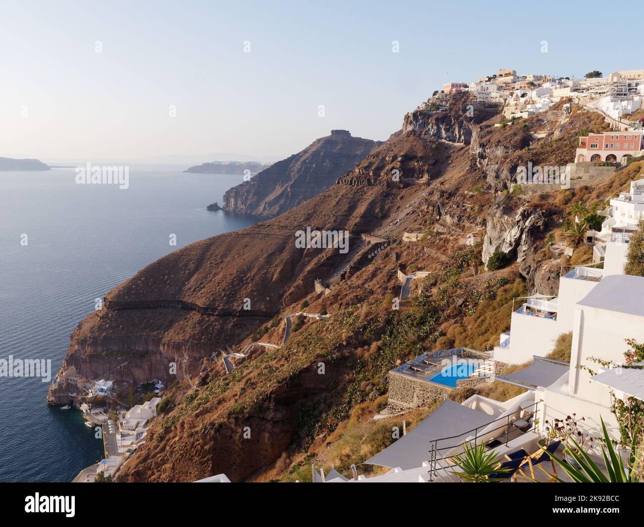 Vista da Fira lungo la costa verso Skaros Rock. Isole Cicladi greche di Santorini nel Mar Egeo Porto Vecchio sotto Foto Stock