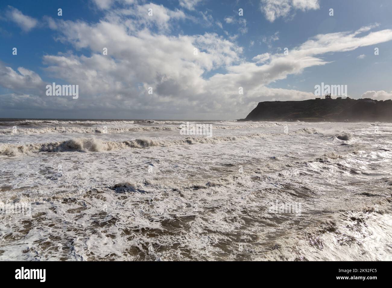 Scarborough, Regno Unito: Mari tempestosi in alta marea sulla costa della North Bay, con il famoso castello sulla scogliera della città dello Yorkshire sullo sfondo Foto Stock