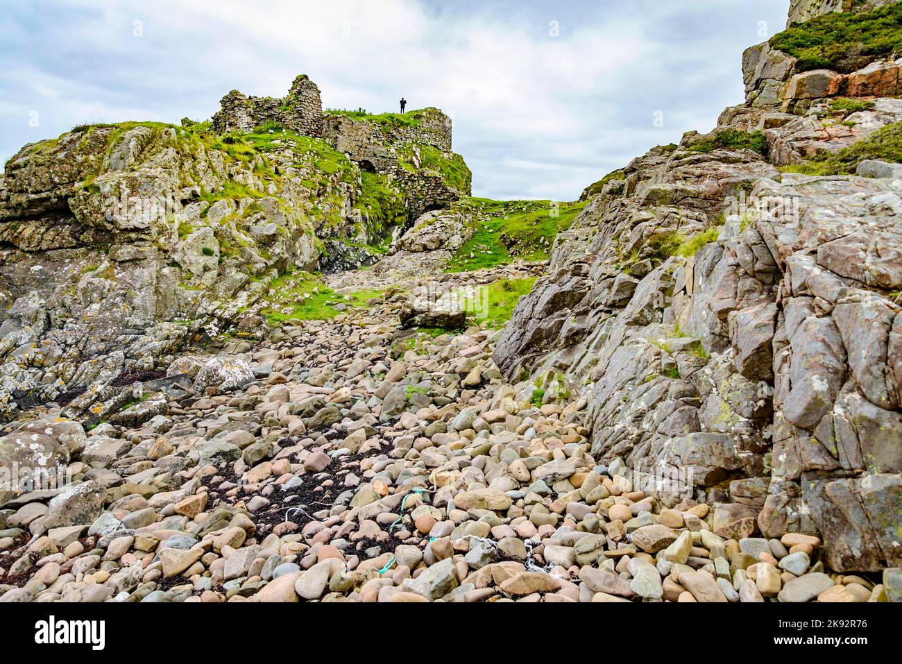 Affacciato sul mare di Loch Slapin, a metà estate il castello scozzese rimane, guardando giù su molte rocce sciolte e ciottoli. Foto Stock
