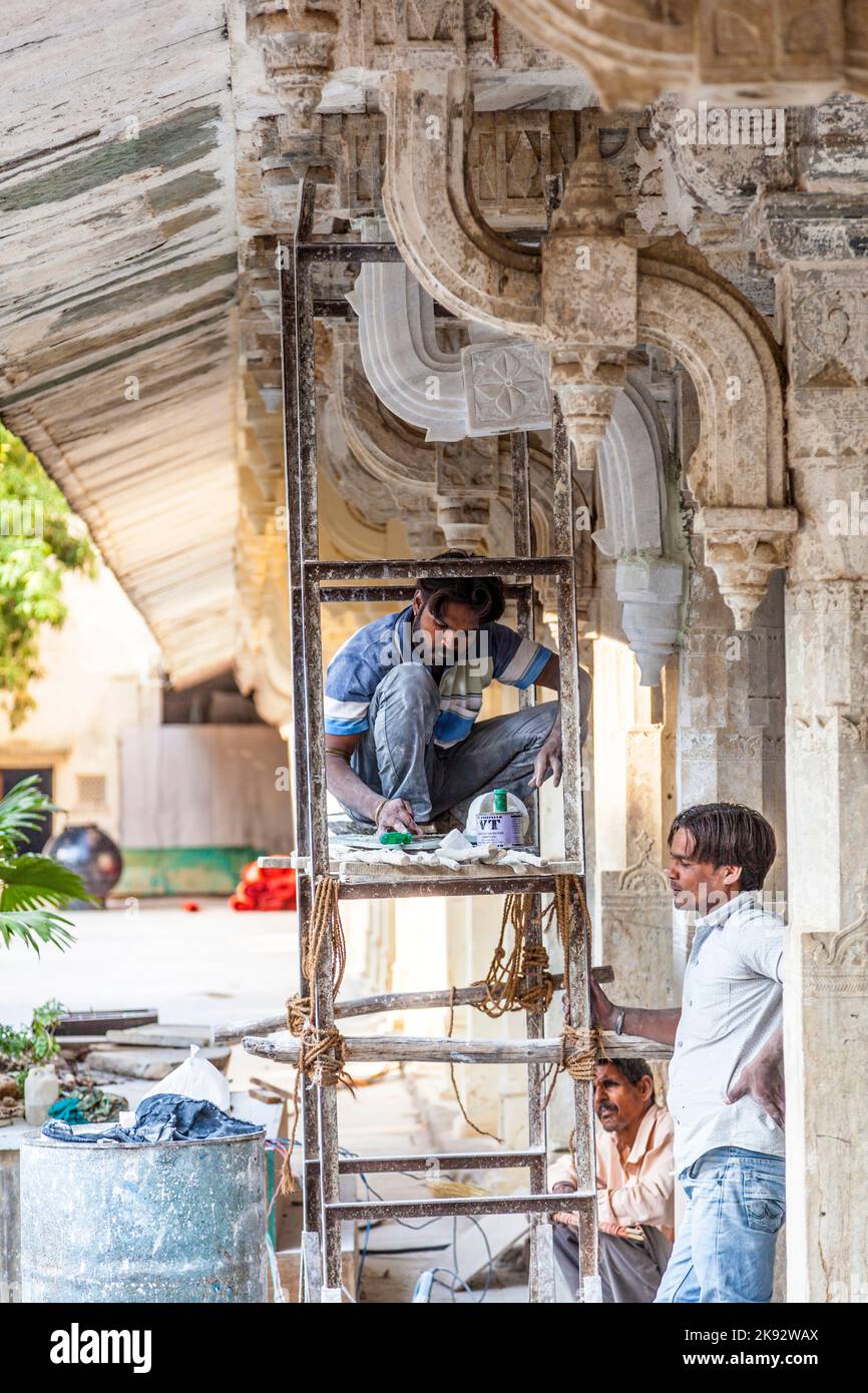 UDAIPUR, INDIA - Oct 21, 2012: Operaio riparare la facciata del palazzo della città a Udaipur, India. La fondazione del forte fu posta nel 1559 da Udai Sin Foto Stock