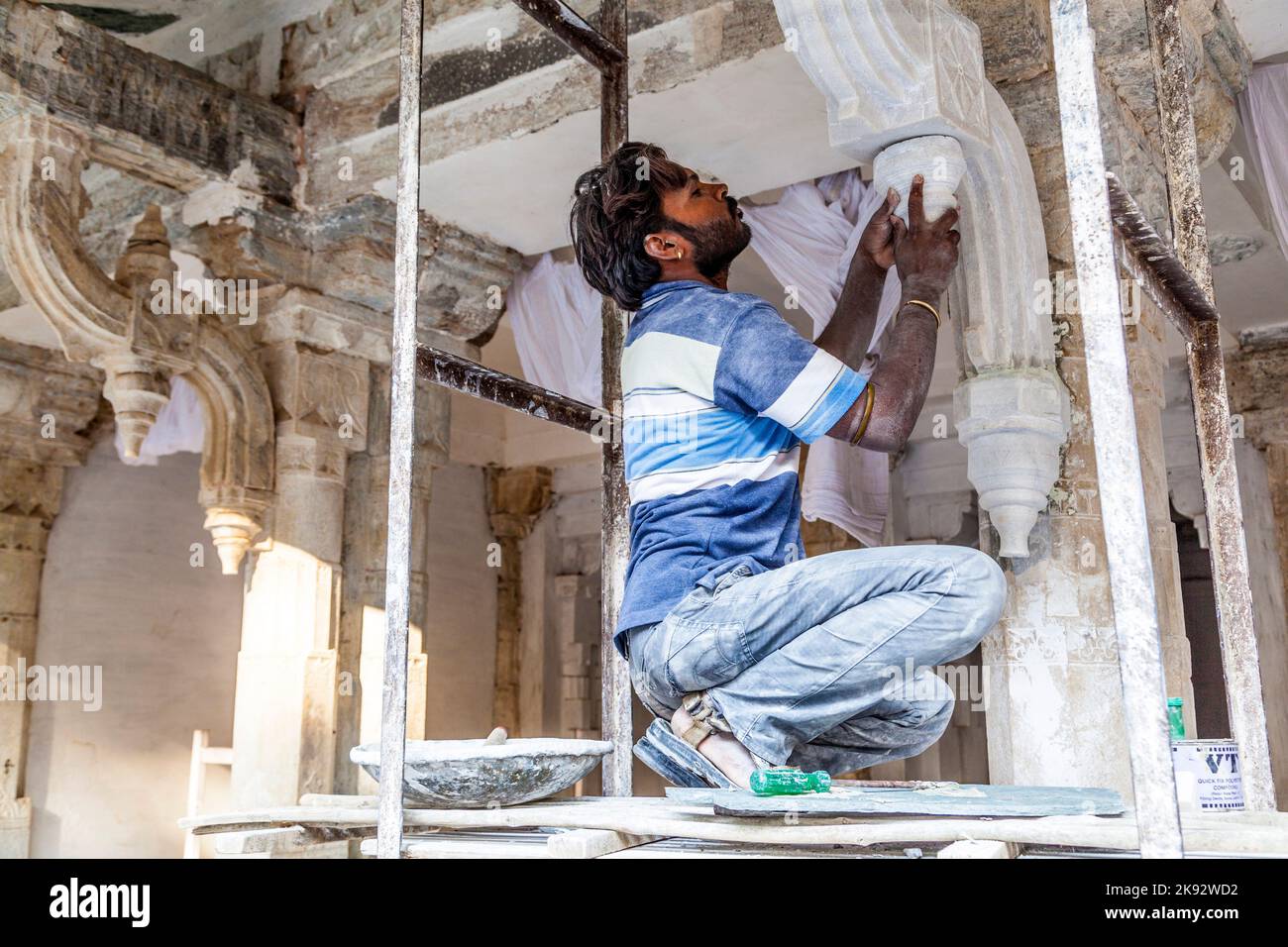 UDAIPUR, INDIA - Oct 21, 2012: Operaio riparare la facciata del palazzo della città a Udaipur, India. La fondazione del forte fu posta nel 1559 da Udai Sin Foto Stock