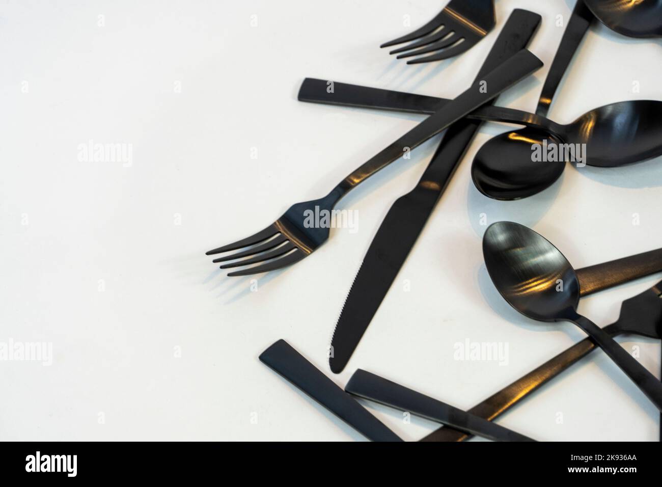 Metallo nero Dinnerware utensili da cucina, Forks coltelli, cucchiai su sfondo grigio mexcio Foto Stock