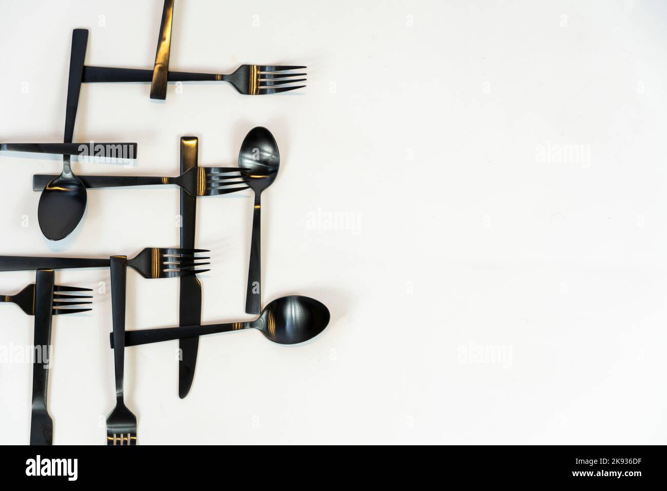 Metallo nero Dinnerware utensili da cucina, Forks coltelli, cucchiai su sfondo grigio mexcio Foto Stock
