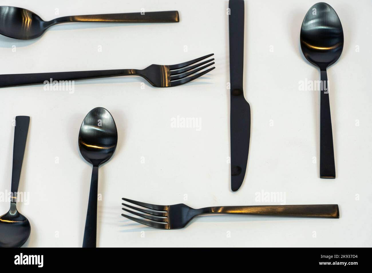 Metallo nero Dinnerware utensili da cucina, Forks coltelli, cucchiai su sfondo grigio mexcio Foto Stock