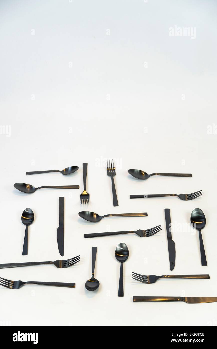 Metallo nero Dinnerware utensili da cucina, Forks coltelli, cucchiai su sfondo grigio mexcio Foto Stock