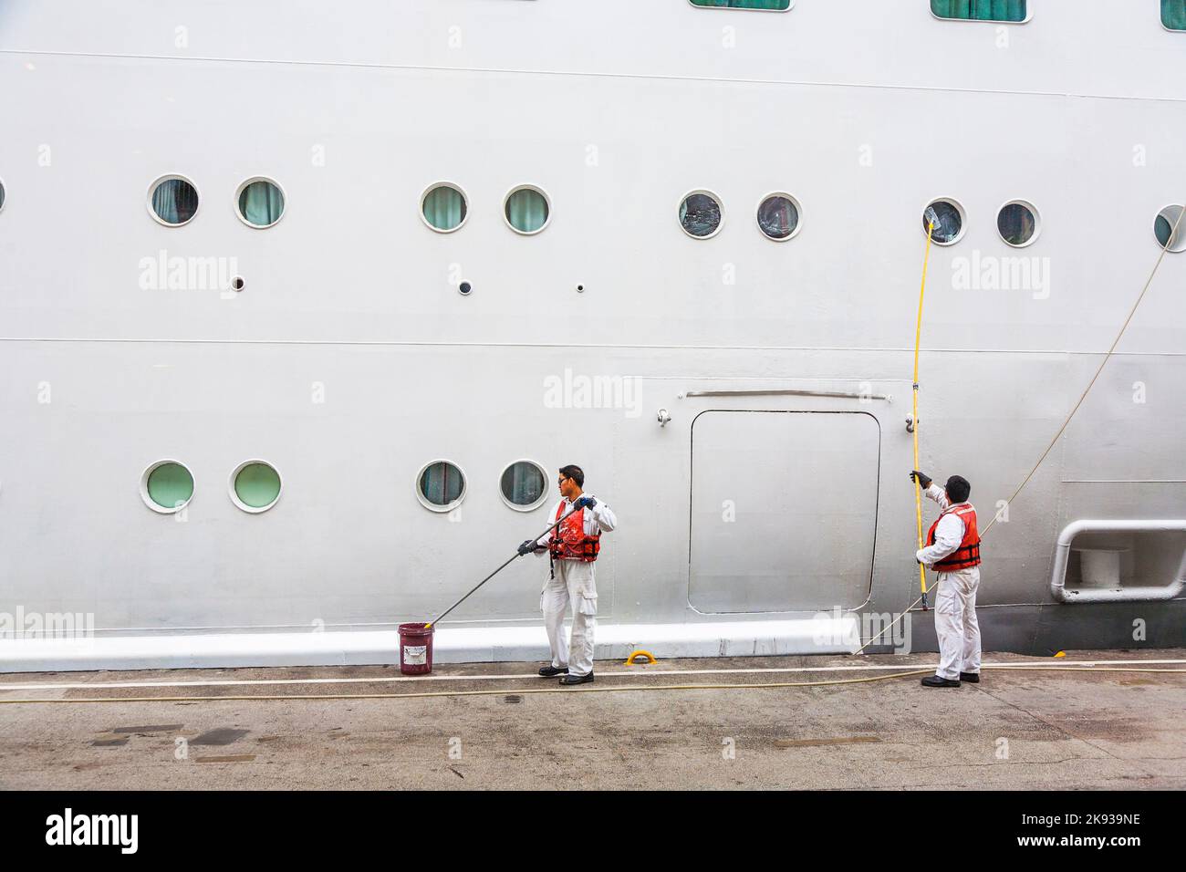 HONG KONG - GENNAIO 8: Lavoratore pulire il lato della nave un incrociatore il 8 Gennaio 2010 a Hong Kong. I terminal delle navi da crociera di Hong Kong si trovano nel cuore di Foto Stock