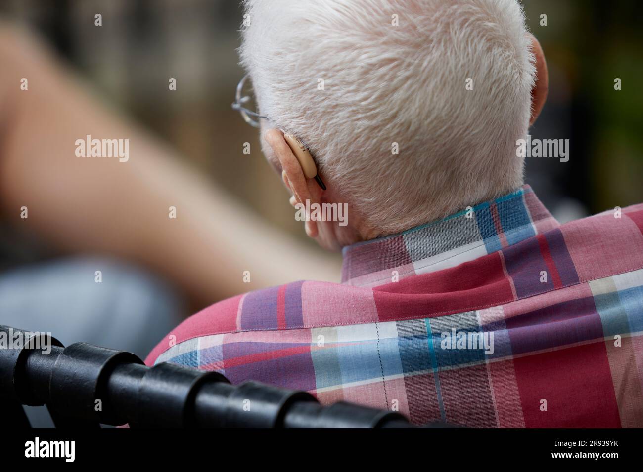 Uomo anziano dai capelli bianchi che indossa apparecchi acustici con profondità di campo bassa Foto Stock