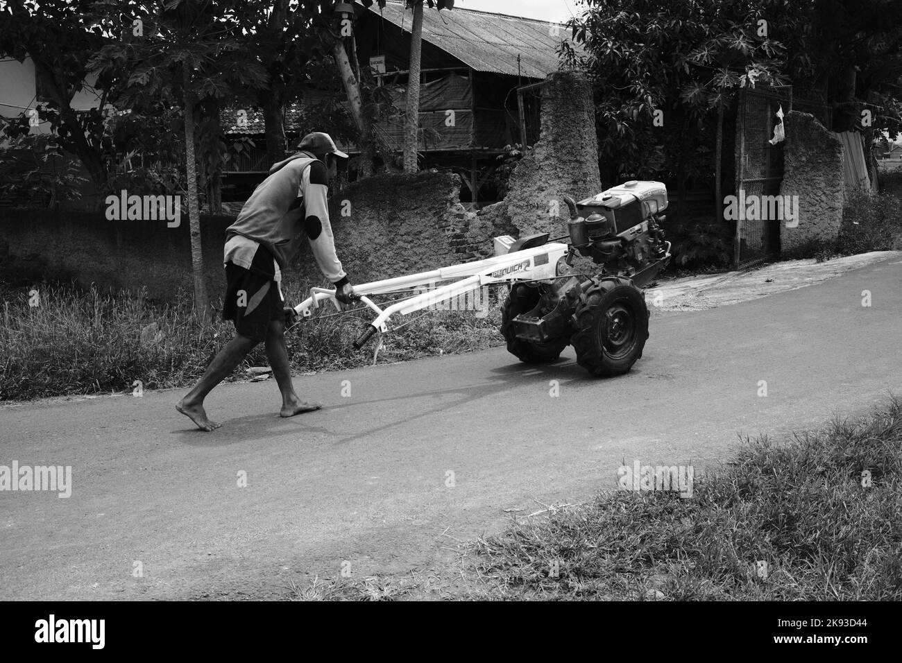 Pangandaran, West Java, Indonesia -17 Ottobre,2022 : Foto in bianco e nero, Foto monocromatica dell'uomo che spinge un trattore nella zona di Cikancung - Indonesia Foto Stock