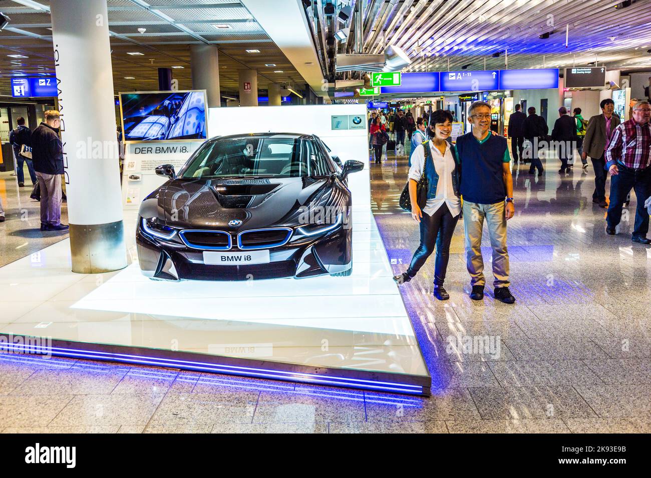FRANCOFORTE, GERMANIA - 28 AGOSTO 2014: La gente posa davanti alla BMW nera della serie i8 innovativa. Stand pubblicitario nel terminal passeggeri, aeroporto Foto Stock