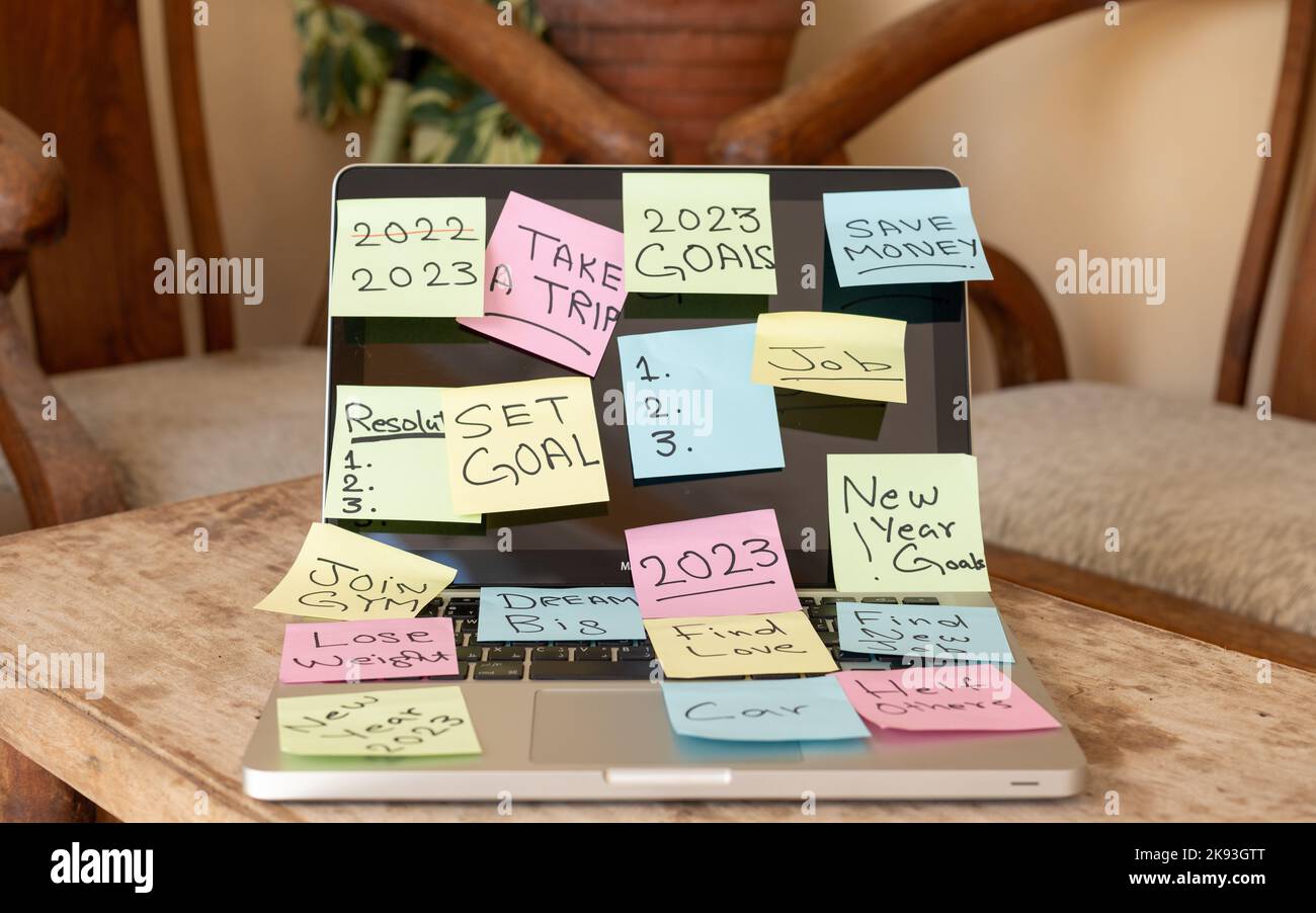 Obiettivi e risoluzione del nuovo anno 2023 scritti su un foglietto adesivo incollato su un notebook Foto Stock