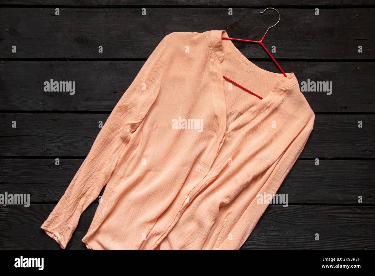 blusa donna di seta leggera si trova su un tavolo di legno nero, abbigliamento donna Foto Stock