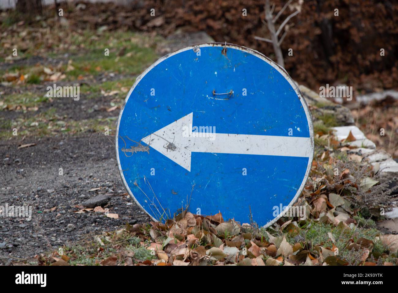 l'indicazione di svolta a sinistra si trova sulla strada in autunno senza un pilastro a terra, cartello stradale Foto Stock