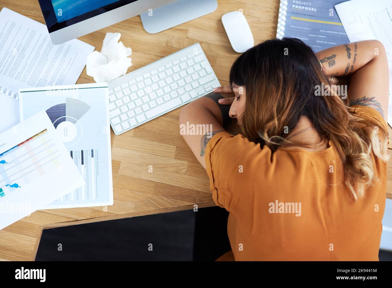 Mi limiterò a fare un pisolino per pochi minuti. Una giovane e attraente donna d'affari dormiva alla scrivania mentre lavorava durante il giorno. Foto Stock