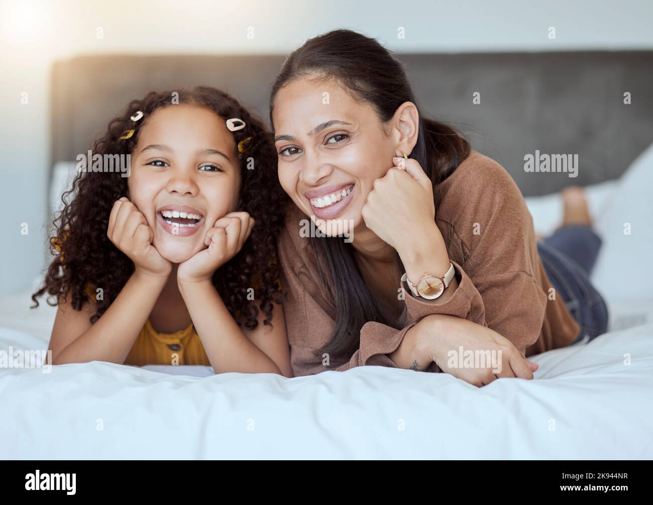Felice, relax e ritratto di madre e ragazza con sorriso sul letto in camera da letto insieme in casa di famiglia. Felicità, amore e donna proveniente dal Messico Foto Stock