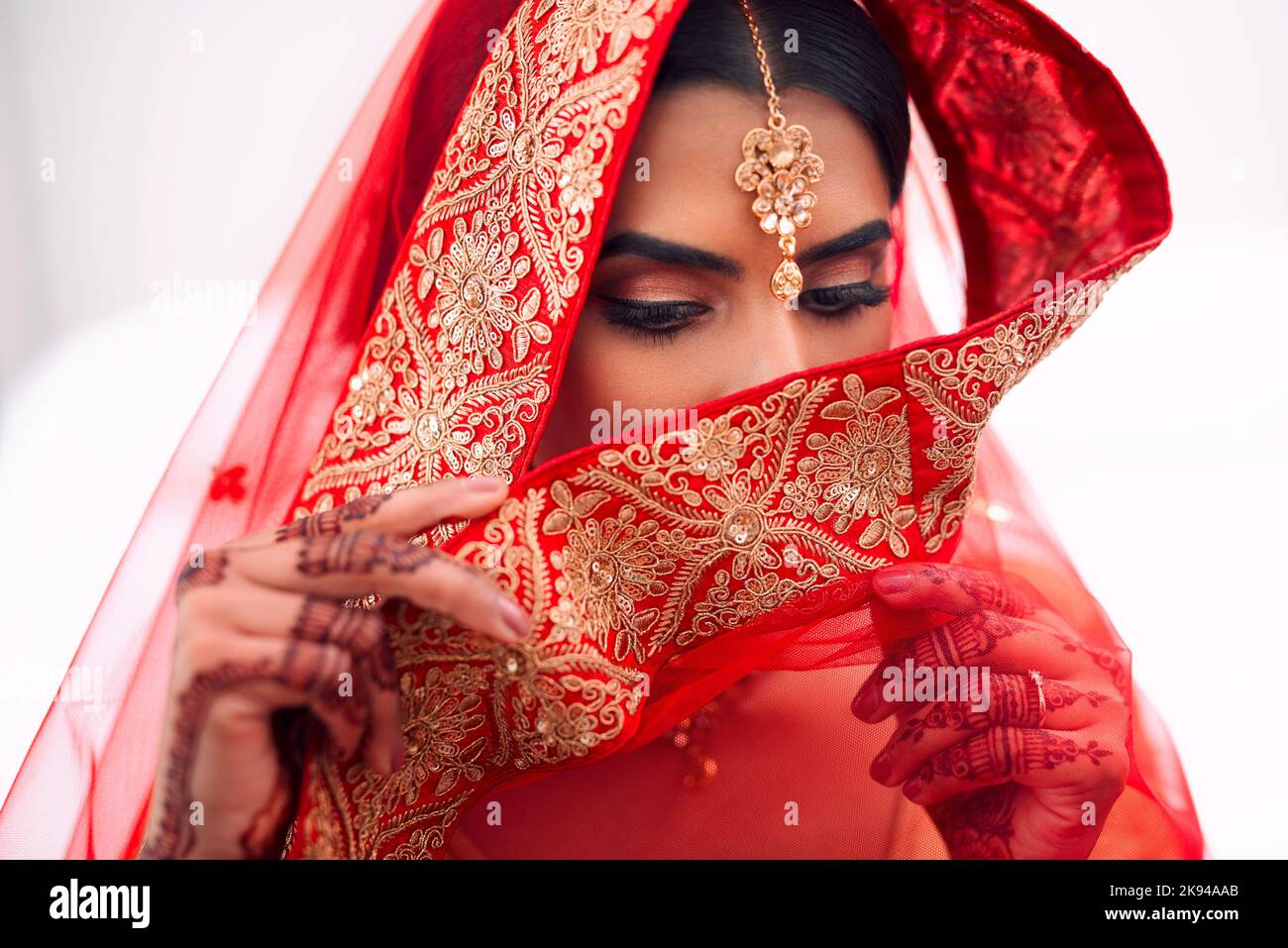 Porta la sua timidezza perfettamente come il suo velo. Una bella sposa indù. Foto Stock