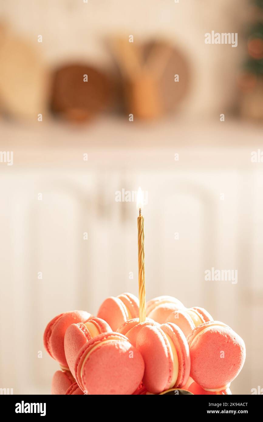 Candela di accensione su torta di macaron su sfondo sfocato Foto Stock